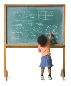 conceptual shot of a young female child as she works out a problem on a chalkboard