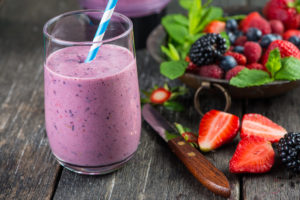 Homemade antioxidant summer fruits smoothie on rustic table