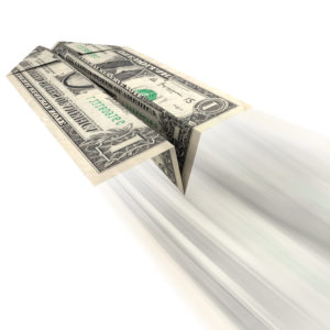 An illustration of a US dollar bill folded into a paper airplane and thrown as related to frivolous spending or expensive debt with little or no return.