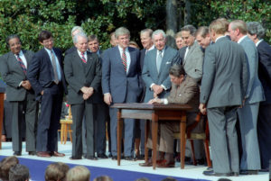10/22/1986 President Reagan signing the Tax Reform Act of 1986 with members of Congress and White House staff present on the south lawn Dole Moynihan Kemp Byrd Regan Rostenkowski Thurmond Baker Gephardt Bush Duncan Kasten Long Rangel